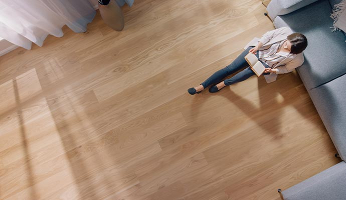 Woman reading book on refinished hardwood floor Woman reading book on refinished hardwood floor